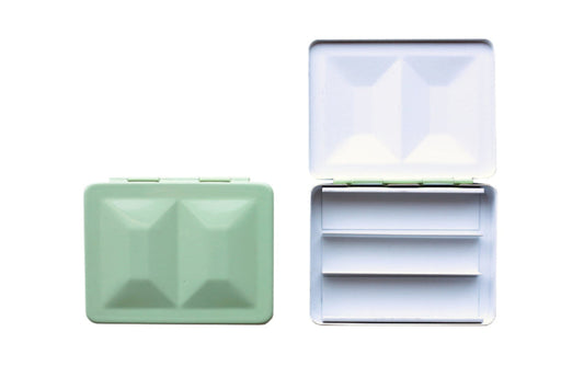 The CfM Simple Travel Palette in Mint. Shown closed and open, side by side. The open case features wells in the lid for mixing colors and can fit a removable swatch card.