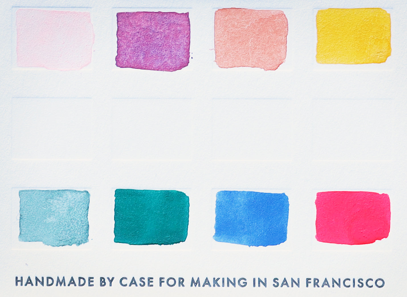 A close-up of the pre-painted swatch card for the 8-Color Outer Sunset Watercolor Travel Palette.