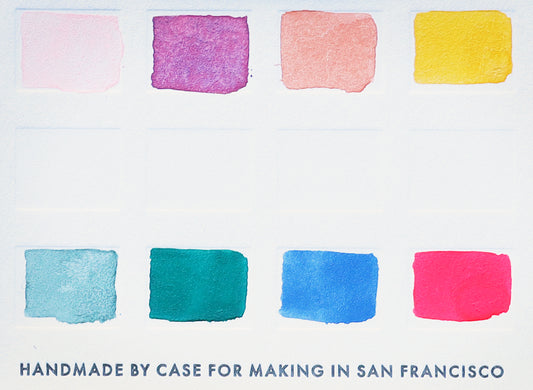 A close-up of the pre-painted swatch card for the 8-Color Outer Sunset Watercolor Travel Palette.