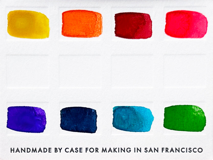 A close-up of the pre-painted swatch card for the 8-Color Rainbow Watercolor Travel Palette.