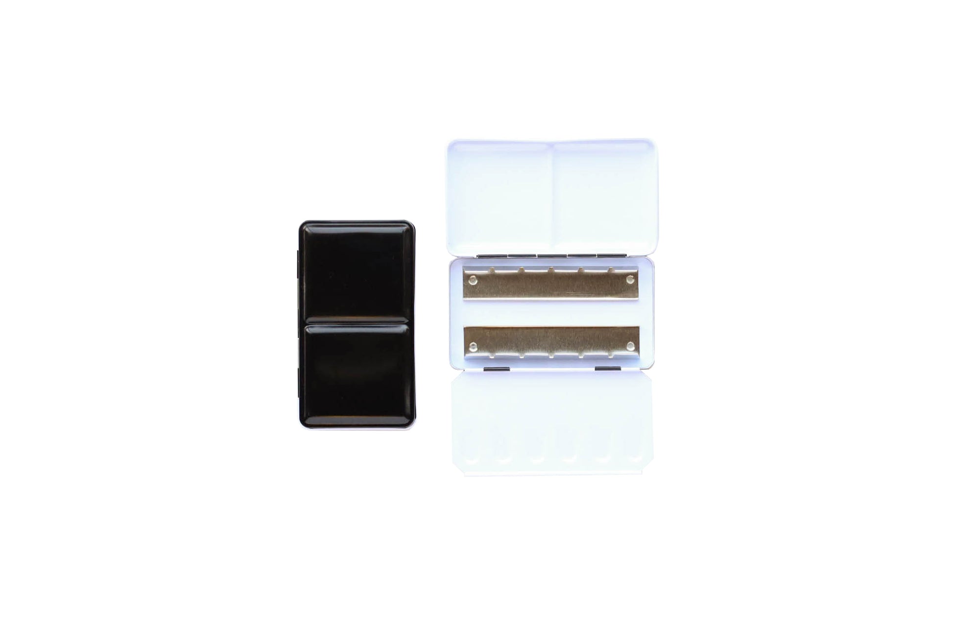 Small Empty Palette - a closed palette beside an open palette.  The exterior is shiny black and the inside is shiny white with mixing space in the lids.  Interior shows 2 empty metal rows that the pans of watercolor clip securely into. 