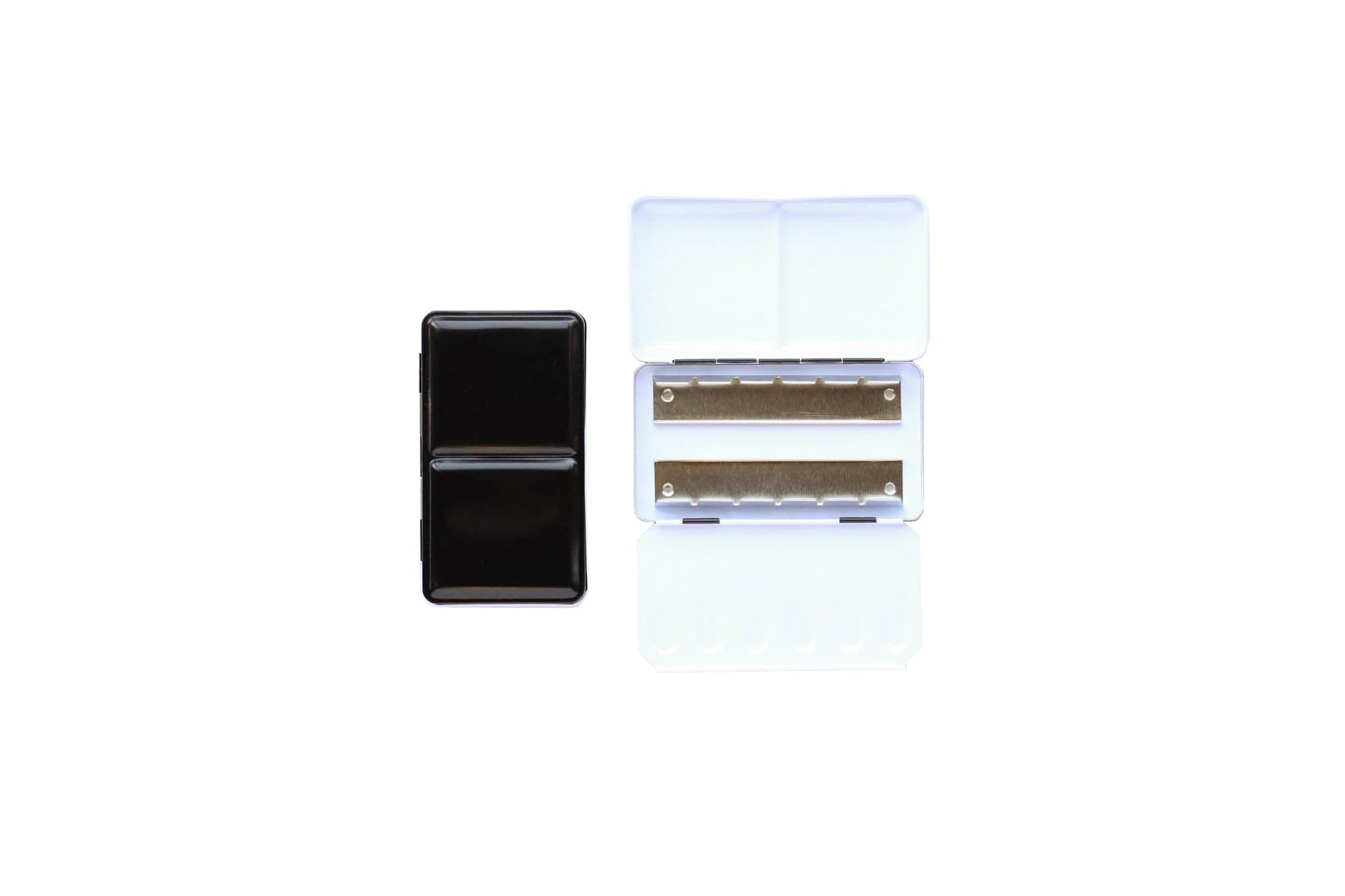 Small Empty Palette - a closed palette beside an open palette.  The exterior is shiny black and the inside is shiny white with mixing space in the lids.  Interior shows 2 empty metal rows that the pans of watercolor clip securely into. 